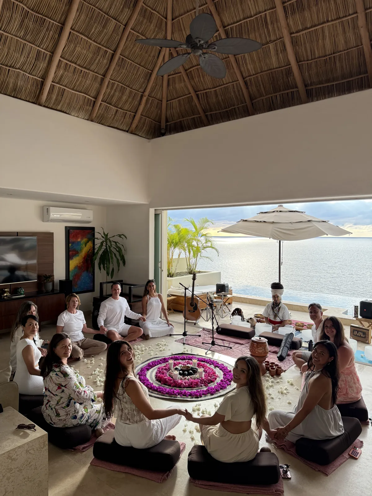 Guests seated around a flower mandala under the palapa