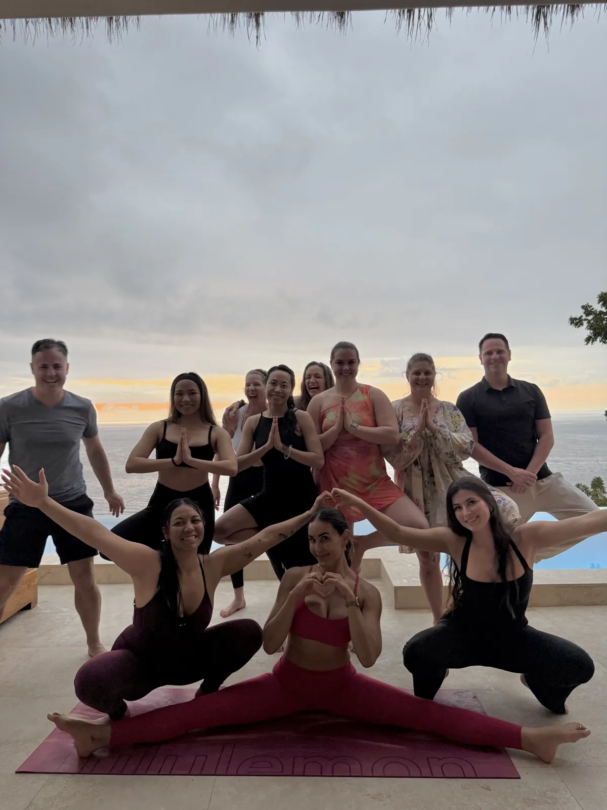 The 2026 group in playful yoga poses at sunset